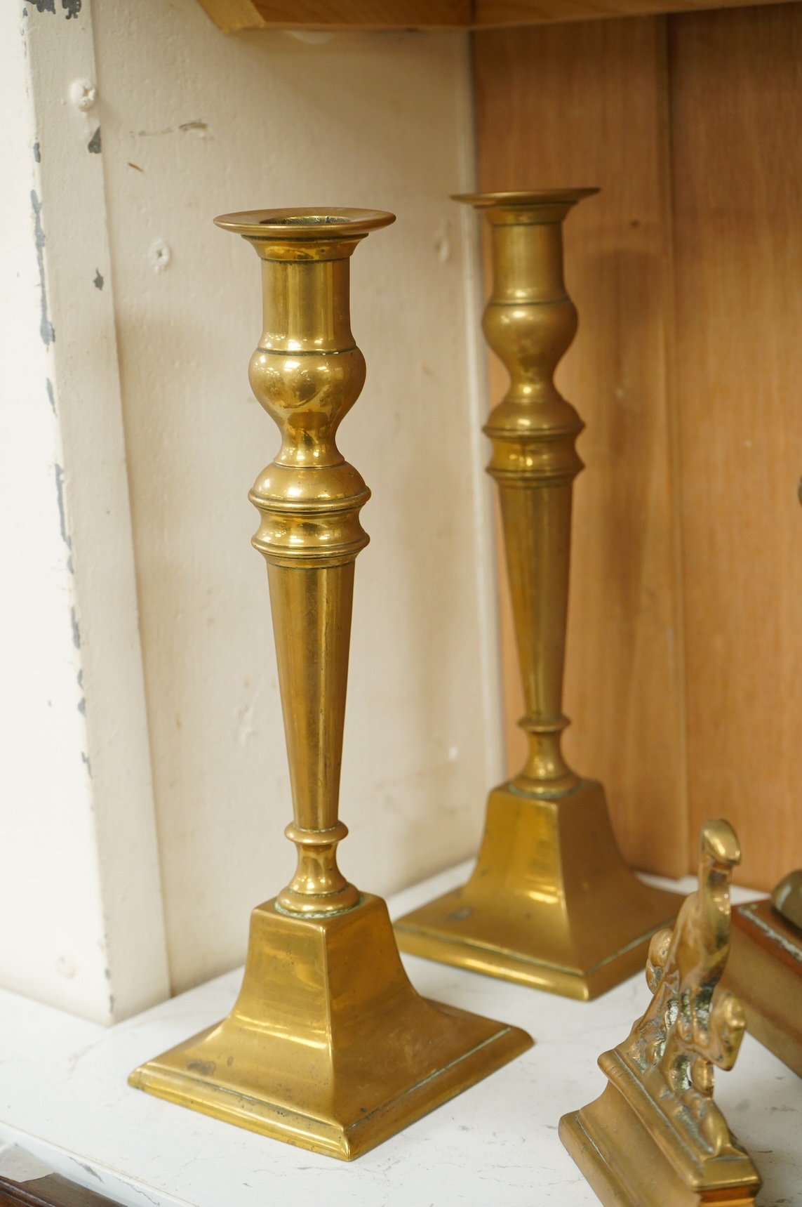 A bronze figure of a horse, two pairs of brass doorstops and a similar pair of candlesticks, 25cm